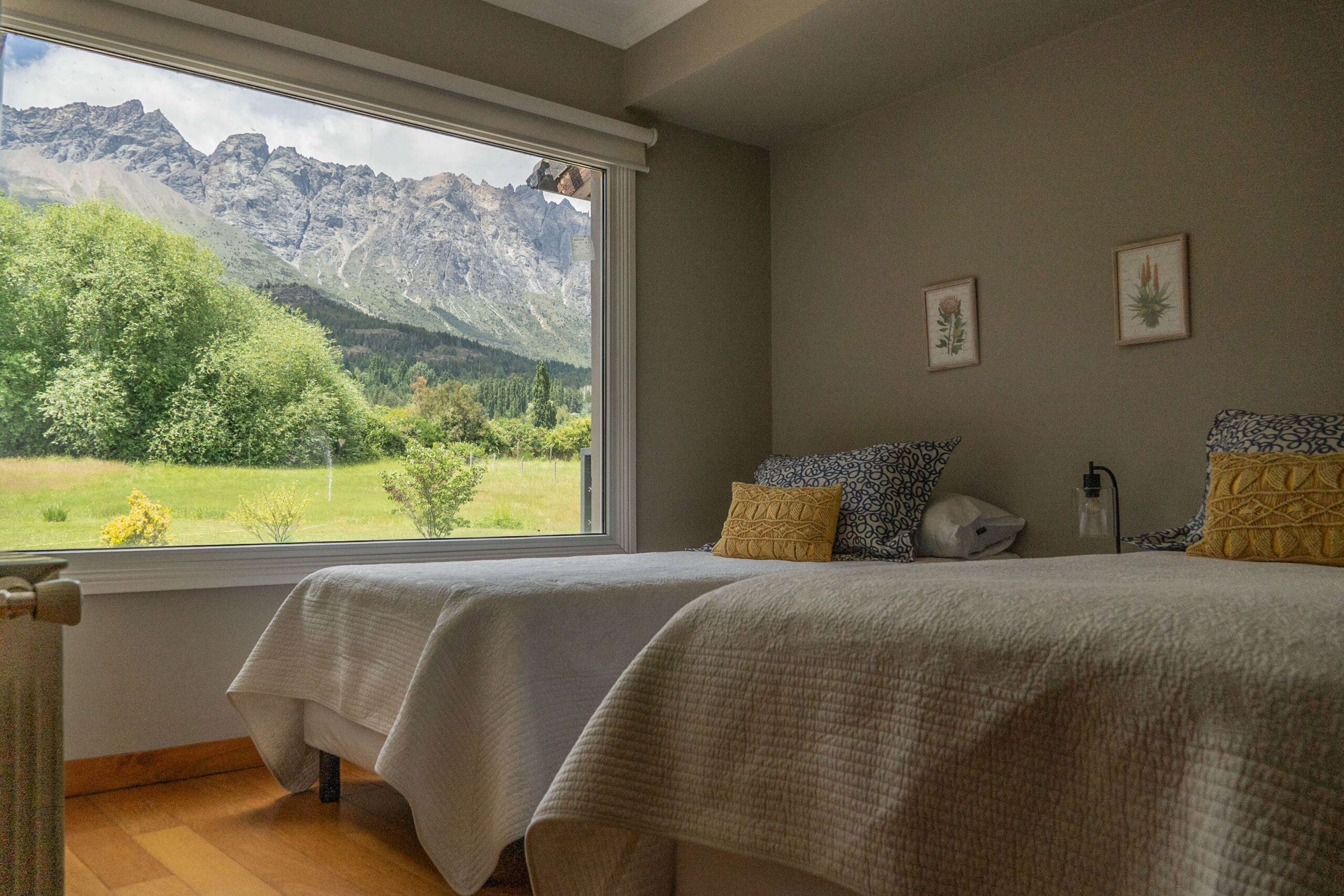 Dormitorio con dos camas individuales y vista a la cordillera en La Aguada Suite, El Bolsón