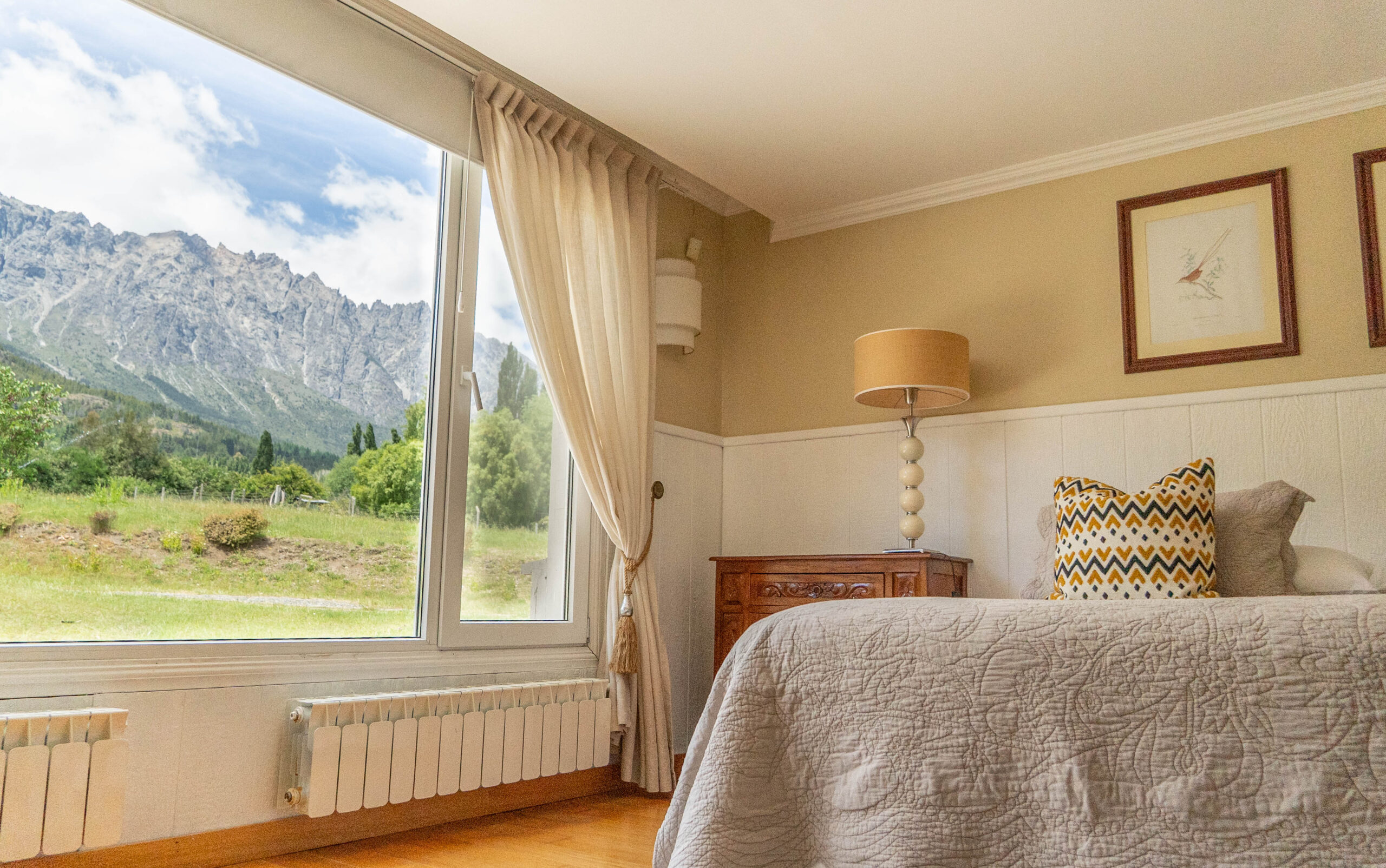Cama king en Habitación Deluxe con ventanal panorámico y vista a la cordillera, La Aguada Suite El Bolsón