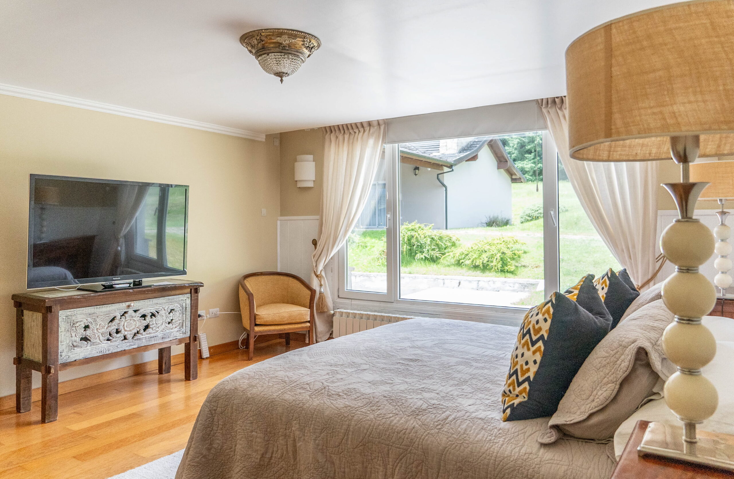 Habitación Deluxe con cama king, TV y ventanal al jardín en La Aguada Suite, El Bolsón