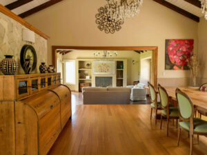 Living y comedor con chimenea, sillones cómodos y decoración cálida en La Aguada Suite, El Bolsón, Patagonia.